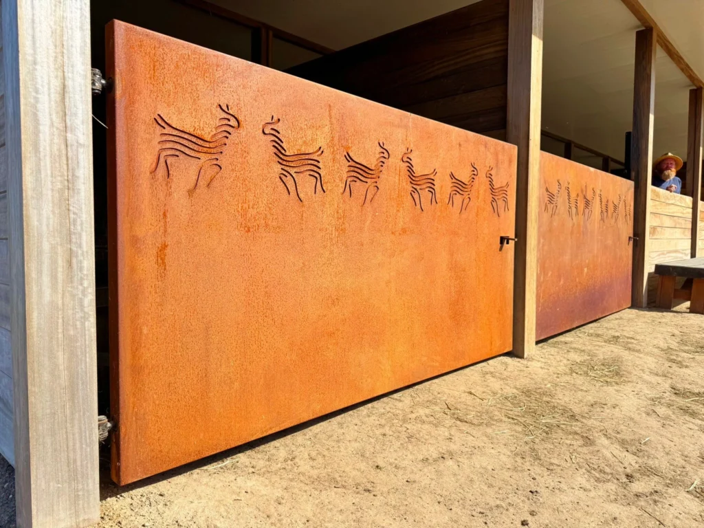 Twee cortenstalen poorten met uitgesneden alpaca‑figuren, volledig in authentiek CORTEN‑A staal