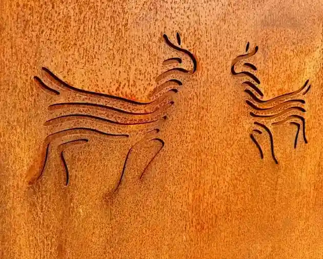 Cortenstalen tuinpoort met uitgesneden alpaca‑figuren in warme roestkleur